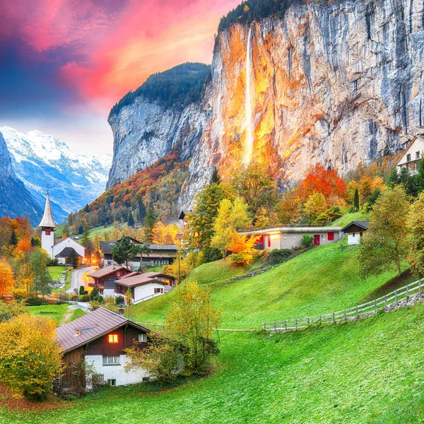Gün batımında muhteşem Staubbach şelalesi ve İsviçre Alpleri ile Lauterbrunnen Vadisi 'nin büyüleyici sonbahar manzarası. Konum: Lauterbrunnen Köyü, Berner Oberland, İsviçre, Avrupa.