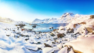 Moskenesoya ve Flakstadoya adalarını ayıran Sundstraumen Boğazı 'nın olağanüstü kış manzarası. Kayalık kıyı şeridi çatlamış buzla kaplı. Konum: Flakstadoya Adası Lofoten; Norveç, Avrupa