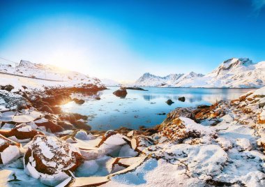 Moskenesoya ve Flakstadoya adalarını birbirinden ayıran Sundstraumen boğazının şaşırtıcı kış manzarası. Kayalık kıyı şeridi çatlamış buzla kaplı. Konum: Flakstadoya Adası Lofoten; Norveç, Avrupa