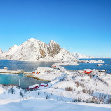 Arka planda Festheltinden zirvesi olan Olenilsoya adasından görülen Hamnoy balıkçı köyü ve köprüsünün muhteşem kış manzarası. Konum: Olenilsoya Adası, Lofoten; Norveç, Avrupa