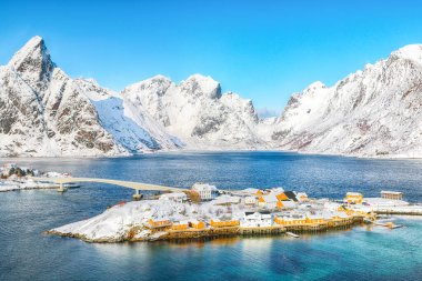 Arka planda Sakrisoy köyü ve karlı dağların kış manzarası. Lofotens 'ta popüler bir turizm merkezi. Konum: Sakrisoy, Moskenesoya, Lofoten; Norveç, Avrupa