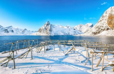 Hamnoy Köyü ve Olstinden Tepesi 'nin arka planında muhteşem bir kış manzarası var. Bir sürü boş kurutma rafı. Konum: Hamnoy, Moskenesoya, Lofoten; Norveç, Avrupa