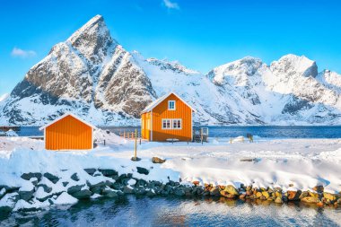 Arka planda Sakrisoy köyü ve karlı dağların şaşırtıcı kış manzarası. Lofotens 'ta popüler bir turizm merkezi. Konum: Sakrisoy, Moskenesoya, Lofoten; Norveç, Avrupa