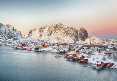 Reine kasabasının muhteşem akşam manzarası. Reinefjorden sahilinde kırmızı ajanlar var. Lofotens 'ta popüler bir seyahat yeri. Konum: Reine, Lofoten; Norveç, Avrupa