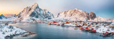 Reine kasabasının muhteşem akşam manzarası. Reinefjorden sahilinde kırmızı ajanlar var. Lofotens 'ta popüler bir seyahat yeri. Konum: Reine, Lofoten; Norveç, Avrupa