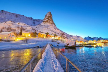 Hammarskaftet Dağı tepesinde kış günbatımı manzarası ve Gravdalbukta körfezi üzerinde yaya köprüsü. Konum: Reine, Lofoten; Norveç, Avrupa
