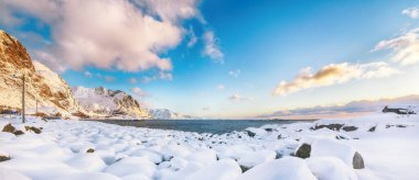 Hamnoy köyü yakınlarında muhteşem bir kış manzarası var. Arkasında yuvarlak kayalar ve karlı dağ zirveleri var. Konum: Hamnoy, Moskenesoya, Lofoten; Norveç, Avrupa