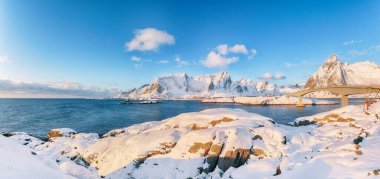 Arka plandaki Hamnoy ve karlı dağlardan Reine ve Sakrisoya köylerinin muhteşem kış manzarası. Konum: Olenilsoya Adası, Lofoten; Norveç, Avrupa