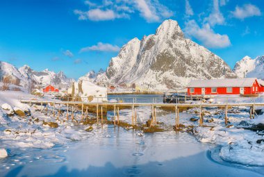Reine Köyü 'nün güneşli kış manzarası ve Gravdalbukta Körfezi' nin yukarısındaki kırık buzlu yaya köprüsü. Konum: Reine, Lofoten; Norveç, Avrupa