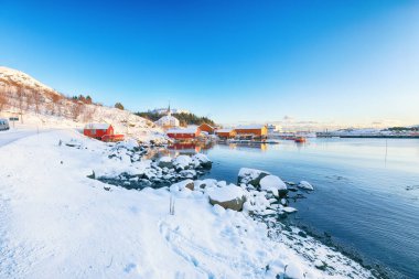 Moskenes köyünün feribot limanı ve ünlü Moskenes kilisesi ile muhteşem kış manzarası. Lofotens 'ta popüler bir seyahat yeri. Konum: Sorvagen, Moskenes, Lofoten; Norveç, Avrupa