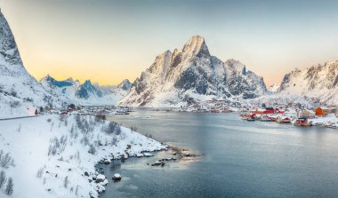 Reine kasabasının muhteşem akşam manzarası. Reinefjorden sahilinde kırmızı ajanlar var. Lofotens 'ta popüler bir seyahat yeri. Konum: Reine, Lofoten; Norveç, Avrupa