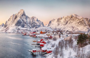 Reine kasabasının muhteşem akşam manzarası. Reinefjorden sahilinde kırmızı ajanlar var. Lofotens 'ta popüler bir seyahat yeri. Konum: Reine, Lofoten; Norveç, Avrupa