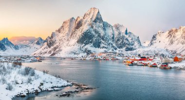 Reine kasabasının muhteşem akşam manzarası. Reinefjorden sahilinde kırmızı ajanlar var. Lofotens 'ta popüler bir seyahat yeri. Konum: Reine, Lofoten; Norveç, Avrupa