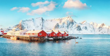 Hamnoy köyü yakınlarındaki Reinefjorden kıyısında geleneksel Norveç kırmızı ahşap evleri (rorbuer). Konum: Hamnoy, Lofoten; Norveç, Avrupa