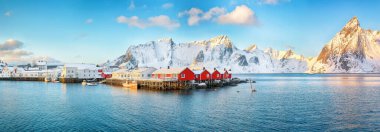 Hamnoy köyü yakınlarındaki Reinefjorden kıyısında geleneksel Norveç kırmızı ahşap evleri (rorbuer). Arka planda Olstinden zirvesi. Konum: Hamnoy, Lofoten; Norveç, Avrupa