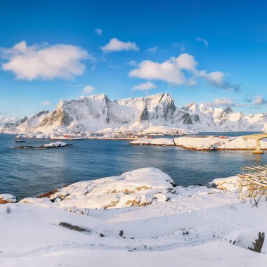 Arka plandaki Hamnoy ve karlı dağlardan Reine ve Sakrisoya köylerinin muhteşem kış manzarası. Konum: Olenilsoya Adası, Lofoten; Norveç, Avrupa