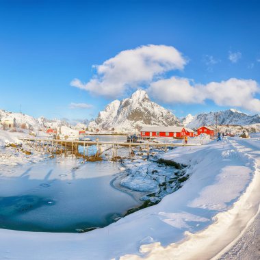 Reine Köyü 'ndeki muhteşem kış güneşli manzarası ve Gravdalbukta Körfezi' nin üzerindeki kırık buzlu yaya köprüsü. Konum: Reine, Lofoten; Norveç, Avrupa