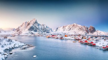 Reine kasabasının muhteşem akşam manzarası. Reinefjorden sahilinde kırmızı ajanlar var. Lofotens 'ta popüler bir seyahat yeri. Konum: Reine, Lofoten; Norveç, Avrupa