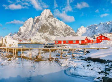 Reine Köyü 'ndeki muhteşem kış güneşli manzarası ve Gravdalbukta Körfezi' nin üzerindeki kırık buzlu yaya köprüsü. Konum: Reine, Lofoten; Norveç, Avrupa