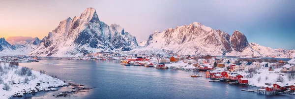 Reine kasabasının muhteşem akşam manzarası. Reinefjorden sahilinde kırmızı ajanlar var. Lofotens 'ta popüler bir seyahat yeri. Konum: Reine, Lofoten; Norveç, Avrupa