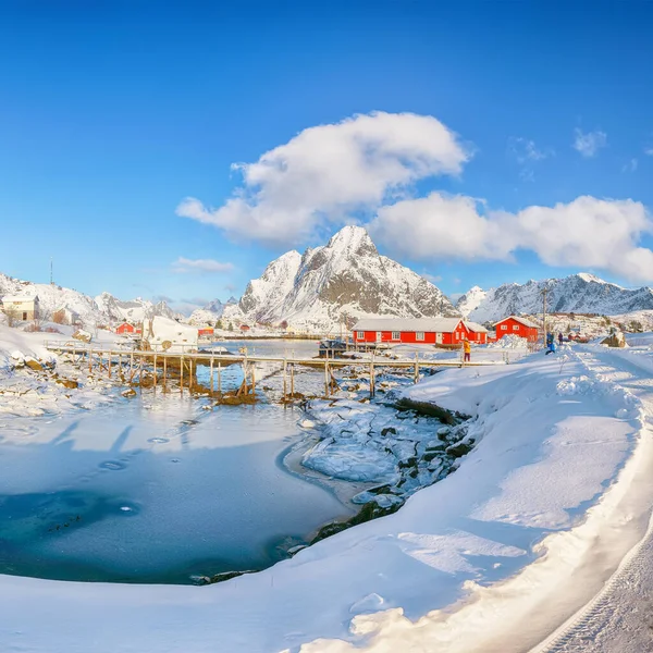 Reine Köyü 'ndeki muhteşem kış güneşli manzarası ve Gravdalbukta Körfezi' nin üzerindeki kırık buzlu yaya köprüsü. Konum: Reine, Lofoten; Norveç, Avrupa