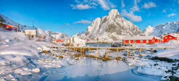 Reine Köyü 'ndeki muhteşem kış güneşli manzarası ve Gravdalbukta Körfezi' nin üzerindeki kırık buzlu yaya köprüsü. Konum: Reine, Lofoten; Norveç, Avrupa