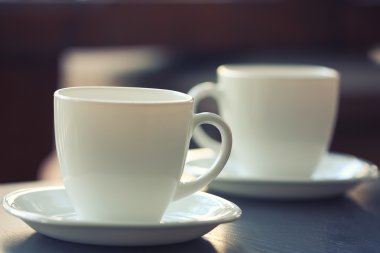 Masaya bir tabak üzerinde beyaz bardak