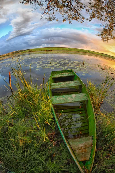 Un paesaggio pittoresco con una barca in canne sul lago — Foto Stock