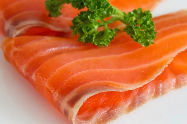 Zalm segmenten met peterselie op wit. — Stockfoto