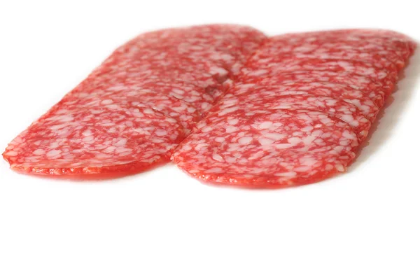 Salami in Scheiben geschnitten auf einem weißen — Stockfoto