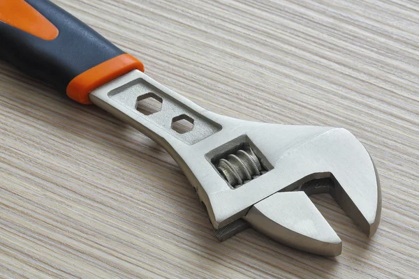 Adjustable wrench closeup on wooden background — Stock Photo, Image