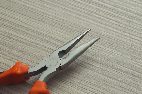 Pliers closeup on wooden background — Stock Photo, Image