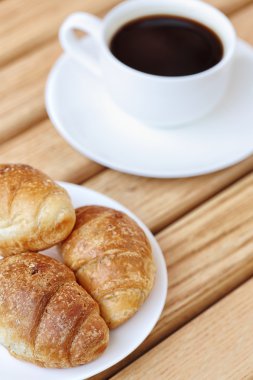 aromalı kahve ve kruvasan bir plaka üzerinde