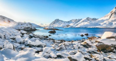 Moskenesoya ve Flakstadoya adalarını ayıran Sundstraumen boğazı. Kayalık kıyı şeridi çatlamış buzla kaplı. Konum: Flakstadoya Adası Lofoten; Norveç, Avrupa