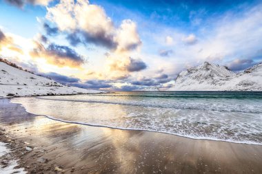 Gün batımında Vik sahilinin muhteşem kış manzarası. Leknes yakınlarında bir sürü kar ve karlı dağ tepeleri var. Konum: Leknes, Vestvagoy, Lofotens, Norveç
