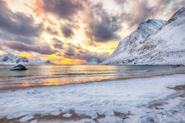 Gün batımında Haukland plajı ve Leknes yakınlarında karlı dağ zirveleri ile inanılmaz bir kış manzarası. Konum: Leknes, Vestvagoy, Lofotens, Norveç