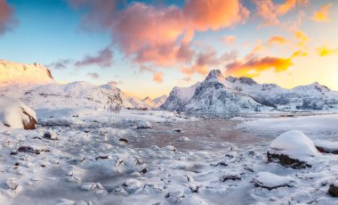 Gündoğumunda buzda çatlaklar olan Flakstadpolen ve Boosen fiyortları şaşırtıcıydı. Arka planda Hustinden dağı vardı. Konum: Flakstadoya Adası, Lofoten; Norveç, Avrupa