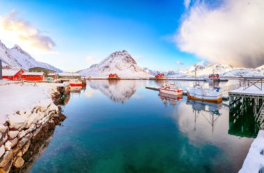 Ramberg köyü ve limanı üzerinde inanılmaz kış gündoğumu. Limanda demirli balıkçı gemileri var. Konum: Ramberg, Flakstadoya Adası, Lofoten; Norveç, Avrupa