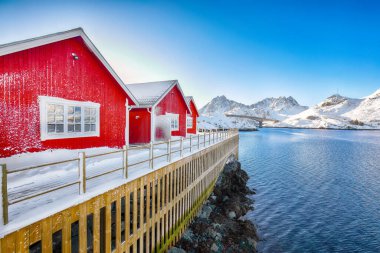 Sundstraumen Boğazı kıyısında geleneksel Norveç kırmızı ahşap evleri olan inanılmaz bir manzara. Konum: Flakstadoya Adası, Lofoten; Norveç, Avrupa