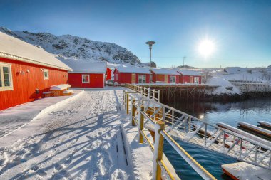 Sundstraumen Boğazı kıyısında geleneksel Norveç kırmızı ahşap evleri olan inanılmaz bir manzara. Konum: Flakstadoya Adası, Lofoten; Norveç, Avrupa