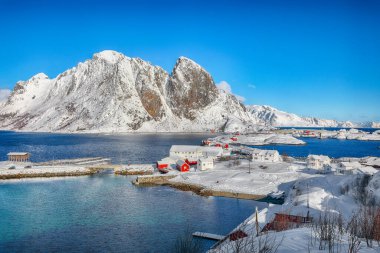 Arka planda Festheltinden zirvesi olan Olenilsoya adasından görülen Hamnoy balıkçı köyü ve köprüsünün muhteşem kış manzarası. Konum: Olenilsoya Adası, Lofoten; Norveç, Avrupa