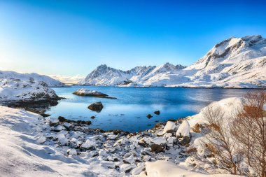Moskenesoya ve Flakstadoya adalarını ayıran Sundstraumen boğazı. Kayalık kıyı şeridi çatlamış buzla kaplı. Konum: Flakstadoya Adası Lofoten; Norveç, Avrupa