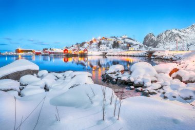 Reine kasabasının muhteşem şehir manzarası. Reinefjorden Shoore 'da kırmızı ajanlar var. Popüler seyahat yeri. Konum: Reine, Lofoten; Norveç, Avrupa
