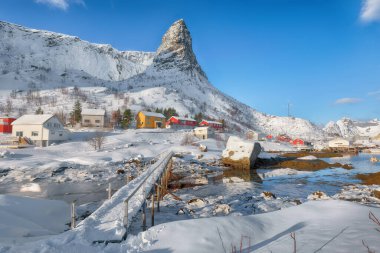 Hammarskaftet Dağı tepesinde kış güneşli manzarası Gravdalbukta körfezi üzerinde yaya köprüsü var. Konum: Reine, Lofoten; Norveç, Avrupa