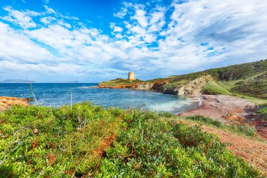 Piscinni Körfezi 'nin turkuaz deniz manzarası ve Piscinni' nin ünlü sahil kulesi. Güzel Akdeniz deniz manzarası. Konum: Teulada, Sardunya, İtalya Avrupa