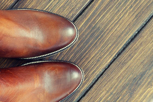 Hnědé boty na dřevěné pozadí — Stock fotografie