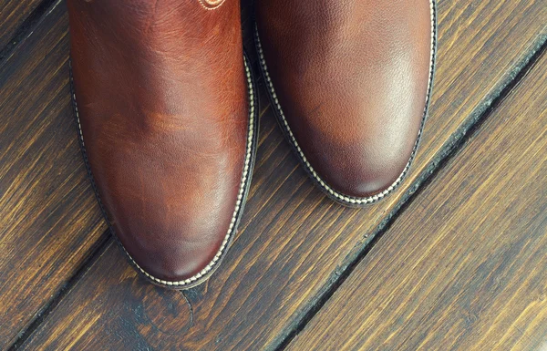 Hnědé boty na dřevěné pozadí — Stock fotografie