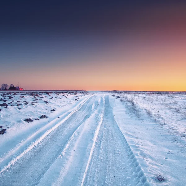 Traços das rodas do carro em uma estrada nevada — Fotografia de Stock