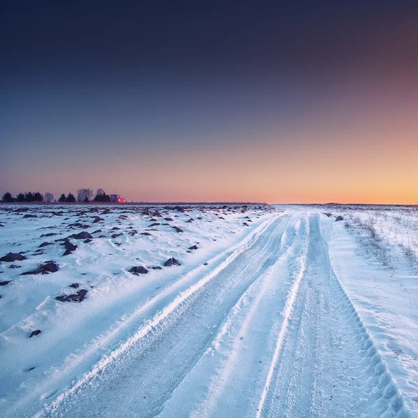 Traços das rodas do carro em uma estrada nevada — Fotografia de Stock