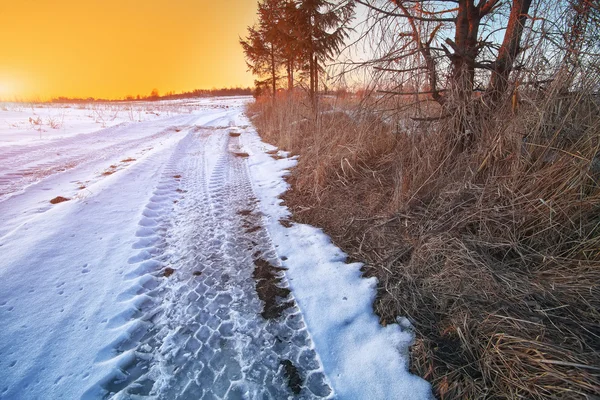 Traços das rodas do carro em uma estrada nevada — Fotografia de Stock